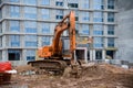 Orange excavator at building under construction. ÃÂ¡onstruction vehicle used to excavate or move large objectsÃÅ½. Royalty Free Stock Photo